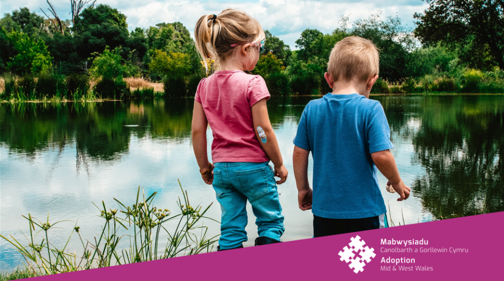 Photograph of siblings standing in front of a lake